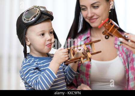 Mutter und Kind Sohn spielen mit Holz- Flächen im Innenbereich. Stockfoto