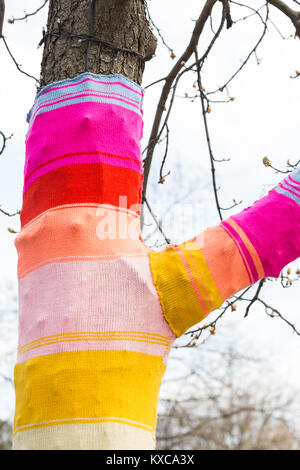 Herbst, Straße Design, Handwerk Konzept. Es ist ein ursprünglich geschmückten Baum, mit gestricktem Fall erstellt der Threads der verschiedenen Farben abgedeckt Stockfoto