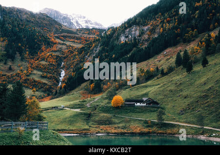 Rocky Mountain mit schleierfall Wasserfall, Bach, Wald, Wiese und Haus in der Nähe der Großglockner Hochalpenstraße in Alpen, Österreich Stockfoto