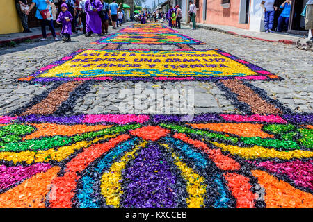 Antigua, Guatemala - März 24, 2016: Einheimische, Spaziergang, vorbei an Sägemehl Gründonnerstag Prozession Teppiche in der Stadt mit den berühmten Heiligen Woche feiern gefärbt Stockfoto