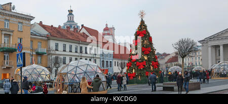 VILNIUS, LITAUEN - 30. Dezember 2017: Weihnachtsbaum auf dem Rathausplatz ist mit roten Bogen- und Glühlampen Girlanden dekoriert Stockfoto