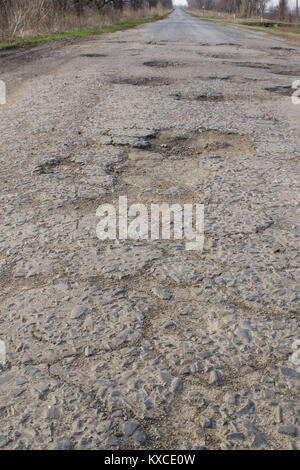 Asphalt schlecht gebrochen Straße mit Gruben und Schlaglöcher Stockfoto