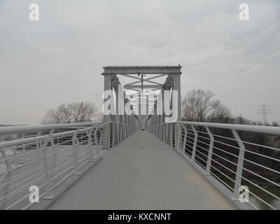 Die Fußgänger- und Radbrücke Kładka Żerańska in Warschau wurde 2017 nach dem Wiederaufbau wieder eröffnet, wobei eine ehemalige Kohleascheleitung über den Kanal Żerański in eine moderne 230 Meter lange Fahrbahn umgewandelt wurde, die Flusswege am rechten Ufer der Stadt verbindet. Der Stahlträger erstreckt sich über vier Felder und verfügt über 1,4 m hohe Sicherheitsgeländer und farbige saisonale Beleuchtung. Stockfoto