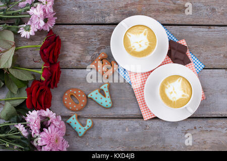 Blumen und Cappuccino, alte Holz- Hintergrund. Stockfoto