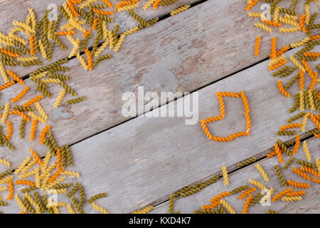 Bunte Nudeln auf alten Holztisch. Stockfoto