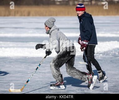 Jungs spielen Eishockey auf einem gefrorenen Teich an einem kalten Tag Stockfoto