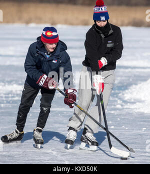 Jungs spielen Eishockey auf einem gefrorenen Teich an einem kalten Tag Stockfoto