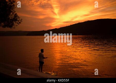 Ein Fischer bei Sonnenuntergang auf der Ostseite des Keuka Lake, New York Stockfoto