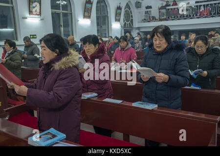 Die Gläubigen singen die Songs während der Heiligabend Gottesdienst in der Herz-Jesu-Kirche in Housangyu Dorf, 70 km westlich von Peking entfernt, eine der frühesten Kirchen in China. 24-Dez-2017 Stockfoto