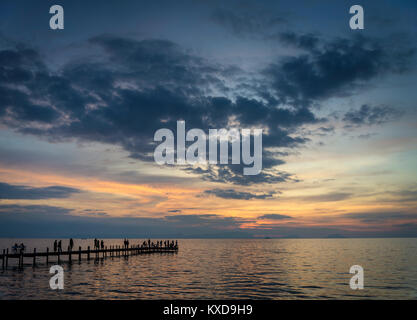 Touristen anzeigen Sonnenuntergang von Pier in Kep Stadt zu Kambodscha Küste Stockfoto