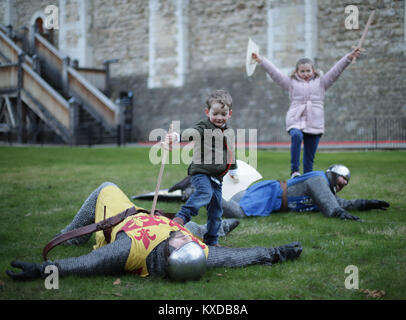 Drei-jährige Rufus Murly-Gotto und 9-jährige Ruby McMenamy Schlacht mit Ritter, während ein Foto für den Start der Ritter Schule an der Tower von London, die die Familien bietet die Möglichkeit, wieder zu einer mittelalterlichen Welt der Heraldik und Valor mit einer Reihe von engagieren und interaktiven Aktivitäten zu reisen, die während der Hälfte Begriff von Samstag 10 Februar bis Sonntag, den 18. Februar. Stockfoto