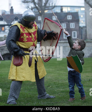 Drei-jährige Rufus Murly-Gotto und einen Ritter in der Schlacht, während ein Foto für den Start der Ritter Schule an der Tower von London, die die Familien bietet die Möglichkeit, wieder zu einer mittelalterlichen Welt der Heraldik und Valor mit einer Reihe von engagieren und interaktiven Aktivitäten zu reisen, die während der Hälfte Begriff von Samstag 10 Februar bis Sonntag, den 18. Februar. Stockfoto