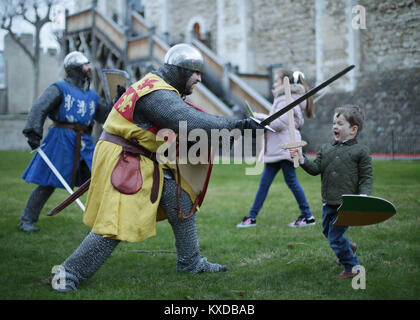 Drei-jährige Rufus Murly-Gotto und einen Ritter in der Schlacht, während ein Foto für den Start der Ritter Schule an der Tower von London, die die Familien bietet die Möglichkeit, wieder zu einer mittelalterlichen Welt der Heraldik und Valor mit einer Reihe von engagieren und interaktiven Aktivitäten zu reisen, die während der Hälfte Begriff von Samstag 10 Februar bis Sonntag, den 18. Februar. Stockfoto