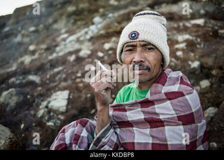 Portrait von Schwefel Miner rauchen Zigarette an Kawah Ijen Vulkan auf Java, Indonesien Stockfoto