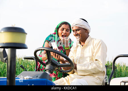 Ländliche Farmer Paar Traktor Farm Text Messaging Telefon Schockiert Stockfoto