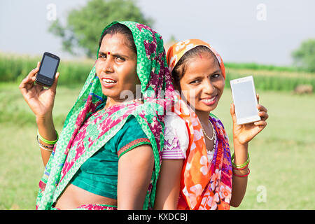 2 Indischen ländlichen Dorfbewohner Damen zusammen mit Smart Phone Farm Stockfoto