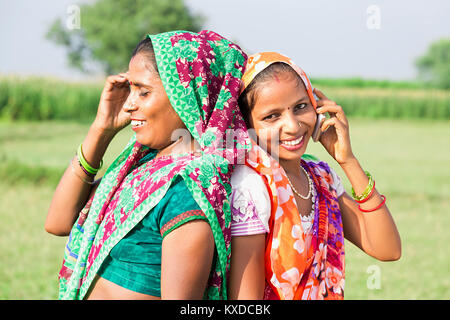 2 Indischen ländlichen Dorfbewohner Damen zusammen gesprochen Feld Telefon Dorf Stockfoto