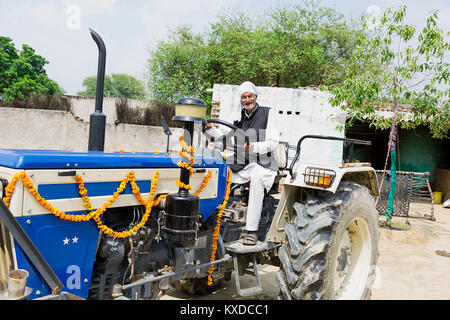 1 Indischen ländlichen Bauern alter Mann reiten Traktor Dorf lächelnd Stockfoto