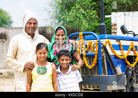 Indische Bauern, Eltern und Kinder in der Nähe von Traktor ländlichen Dorf stehend Stockfoto
