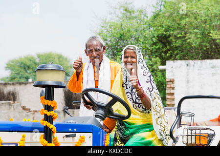 2 Indischen ländlichen Bauern alte Paar Fahrt Zugmaschine mit Thumbsup Stockfoto