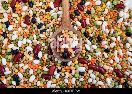 Holzlöffel und gemischte rohe Hülsenfrüchte Stockfoto