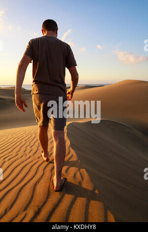 Männer gehen zwischen den Sanddünen von Maspalomas. Insel Gran Canaria. Stockfoto