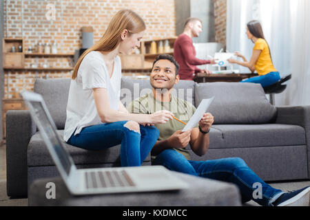 Positive Jugendliche in einem gemütlichen Zimmer sitzen und in ein nettes Gespräch Stockfoto