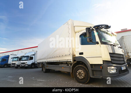 Lkws sind mit Waren im Depot in einer Reederei geladen Stockfoto