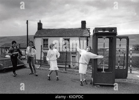 England, Wales, Rhymney, Sozialgeschichte, spielende Kinder durch verlassene K8 Phone Box 1970 s Stockfoto