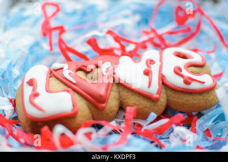 Schreiben von Cookies für den Valentinstag oder für eine Hochzeit auf dem blauen und weißen Papier Füller Hintergrund. Ansicht von oben, selektiver Fokus, kopieren. Stockfoto