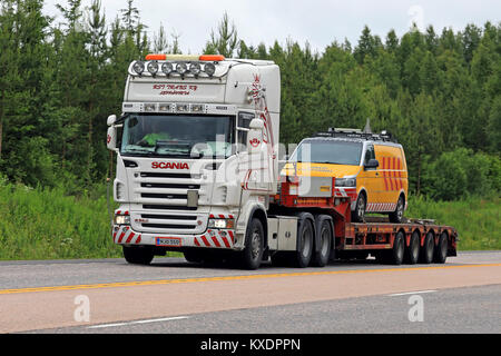 JAMSA, Finnland - 6. JULI 2017: Scania R560 Semi von RST Trans Ky transportiert ein Pilot Fahrzeug für oversize load Transport entlang der Autobahn in zentralen Finlan Stockfoto