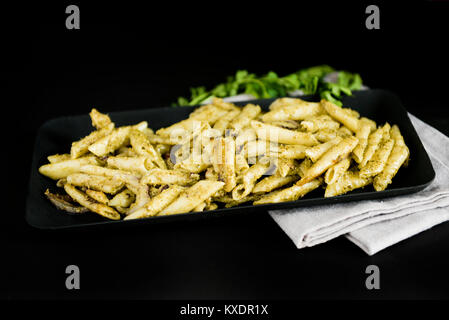 Leckeres Pesto Pasta in schwarz und schwarzem Hintergrund Stockfoto