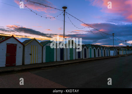 Umkleidekabinen am Strand bei Sonnenuntergang in Paignton, England, Stockfoto