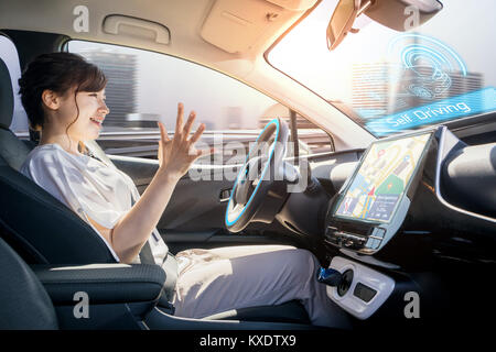Entspannt Frau in autonomen Auto. Selbst das Fahrzeug fahren. Autopilot. Kraftfahrzeugtechnik. Stockfoto