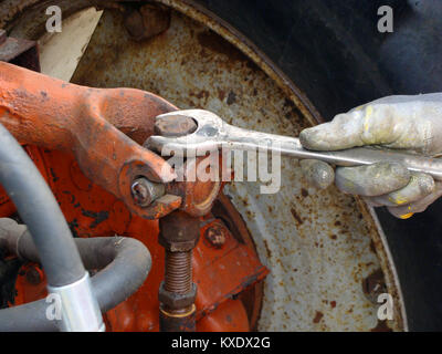 Hand mit einem Schraubenschlüssel drehen der Schraube am Traktor Anhängevorrichtung Nahaufnahme Stockfoto