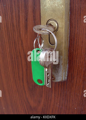 Bündel Schlüssel in das Türschloss und grünen Tag close up Stockfoto
