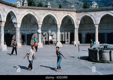 Türkische Jungs, Volleyball oder Fußball im achteckigen Innenhof des c 15 Buyuk Aga Medresse oder Kapi Aga Medresesi, Amasya, Türkei Stockfoto