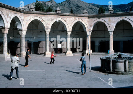 Türkische Jungs, Volleyball oder Fußball im achteckigen Innenhof des c 15 Buyuk Aga Medresse oder Kapi Aga Medresesi, Amasya, Türkei Stockfoto