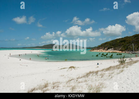 Unberührte weiße Sand von Whitehaven Beach, Cairns, Queensland mit erstaunlichen smaragdgrünen Meer, Coral Sea, blauer Himmel und die Menschen in der Ferne baden. Stockfoto