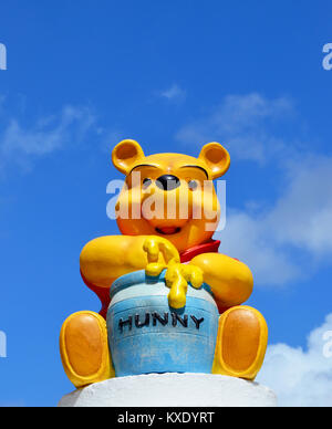 Monchique, Faro - Portugal, Um, April 2013. Studiobild der Figur von Winnie the Pooh, die auf einer Wand mit blauem Himmel sitzt. Stockfoto