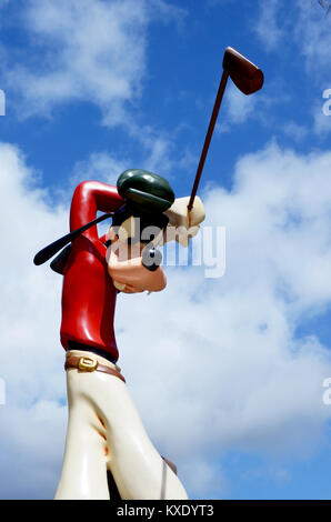 Monchique, Faro - Portugal, Circa, März 2013. Studiobild der Goofy Figur, die einen Golfschläger schwingt, mit einem blauen Himmel Hintergrund. Stockfoto