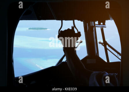 Blick aus dem Wasserflugzeug Cockpit auf hellen Strand destination Malediven kleine Inseln Atoll. Im inneren Ebene ist dunkel Stockfoto