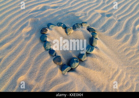 Liebe Herzform aus Steine im Sand Stockfoto