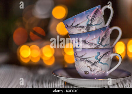 VINTAGE JAPANISCHE MORIAGE HANDBEMALTE Tasse & Untertasse - DRAGON WARE auf Holz Tisch mit Bokeh hellen Hintergrund Stockfoto