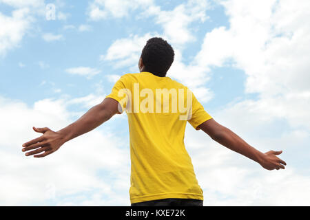 Junge teen Boy mit offenen Händen in den Himmel. Stockfoto