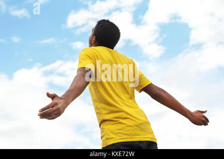 Junge teen Boy mit offenen Händen in den Himmel. Stockfoto