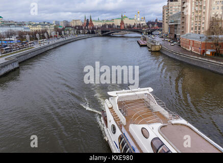 Ein Blick auf den Kreml von der patriarchalischen Brücke. Tauwetter in der Mitte des Winters. Ein Stern von einem Schiff auf dem Fluss Moskau im Vordergrund. Stockfoto