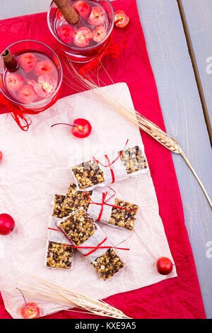 Diät Müsliriegel mit detox Apfel-zimt Wasser auf rote Paprika und Holz- Hintergrund. Ansicht von oben. Flach Stockfoto
