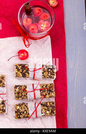 Diät Müsliriegel mit detox Apfel-zimt Wasser auf rote Paprika und Holz- Hintergrund. Ansicht von oben. Flach Stockfoto