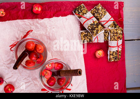 Diät Müsliriegel mit detox Apfel-zimt Wasser auf rote Paprika und Holz- Hintergrund. Ansicht von oben. Flach Stockfoto